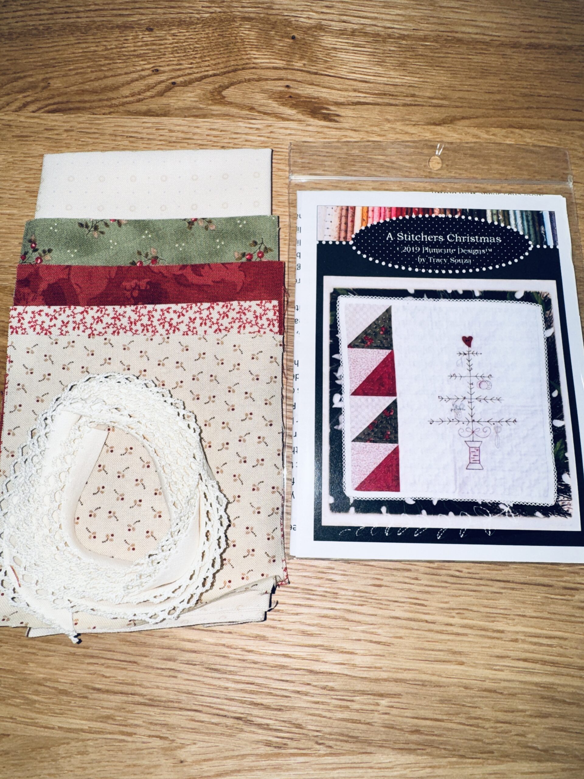 A Stitcher’s Christmas embroidery kit by Plumcute Designs including fabric, trim, and heart button for spool tree design