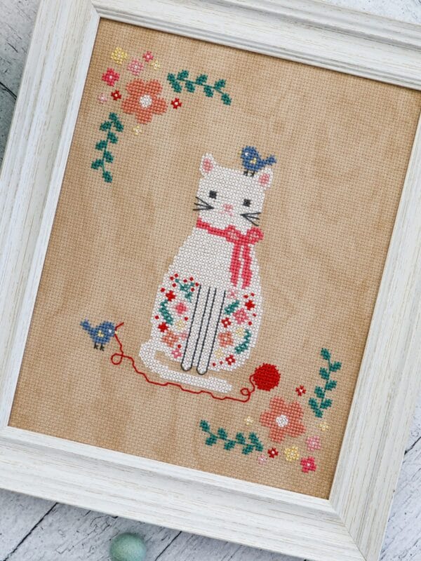 Stitching Friends floral cat cross stitch pattern with white cat bluebirds and flowers