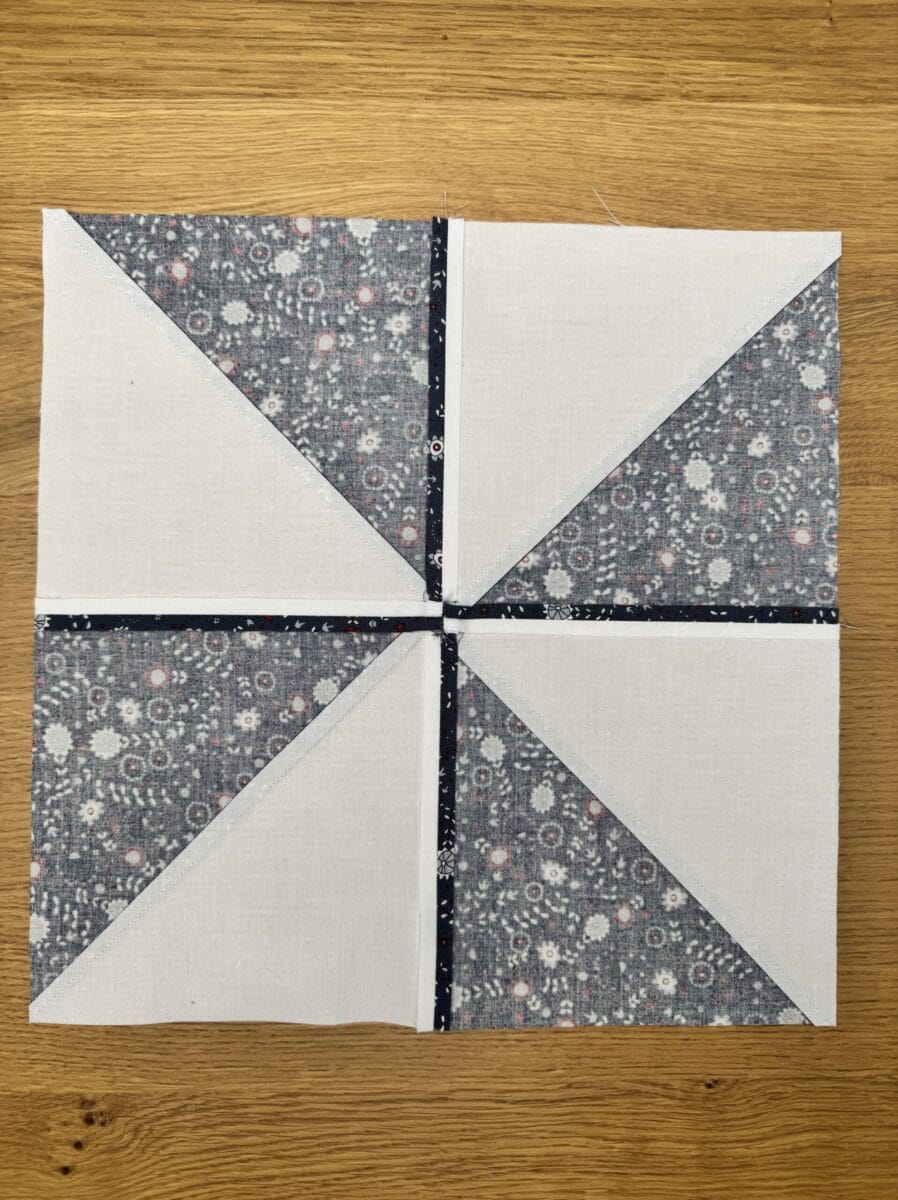 Back of a pinwheel quilt block showing seam placement and pressing directions