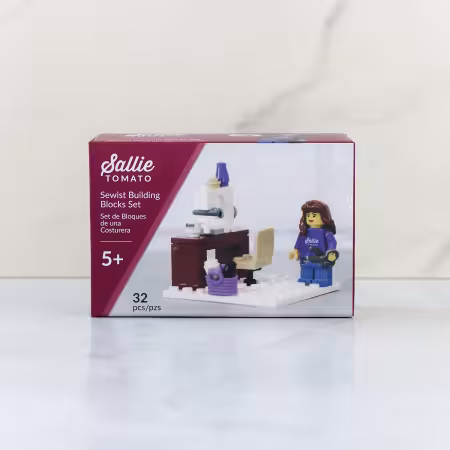Sallie Tomato Sewist Building Block Set featuring a miniature sewing machine station, studio chair, scissors, and sewist minifigure