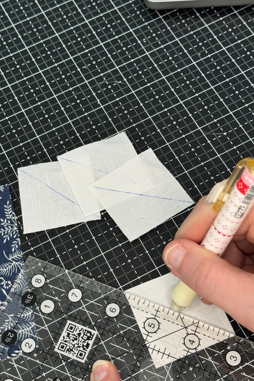 Drawing the diagonal lines on the small squares for sew and flip corners with a heat removable pen