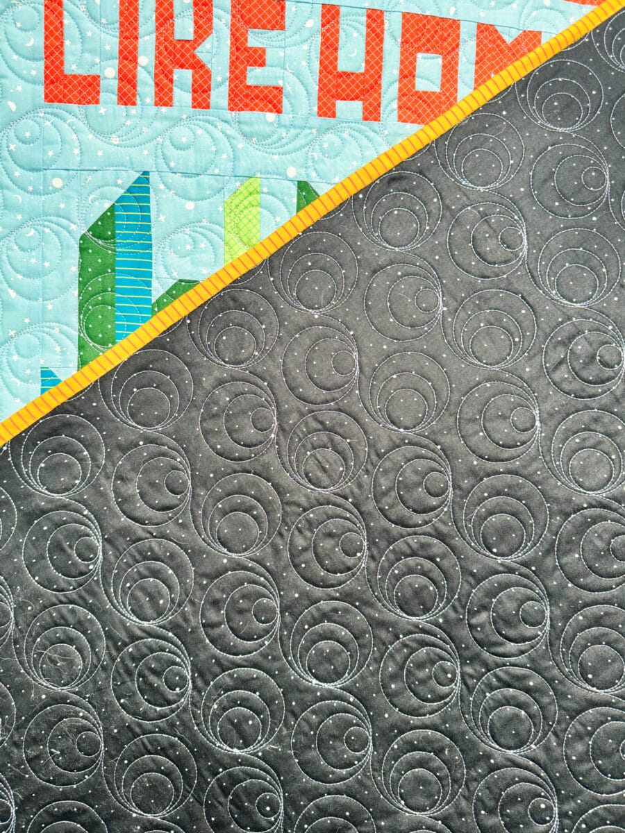 Close up of the Echoed Circles pantograph on the Black Dapple Dot backing on the Sew Place Like Home Quilt.