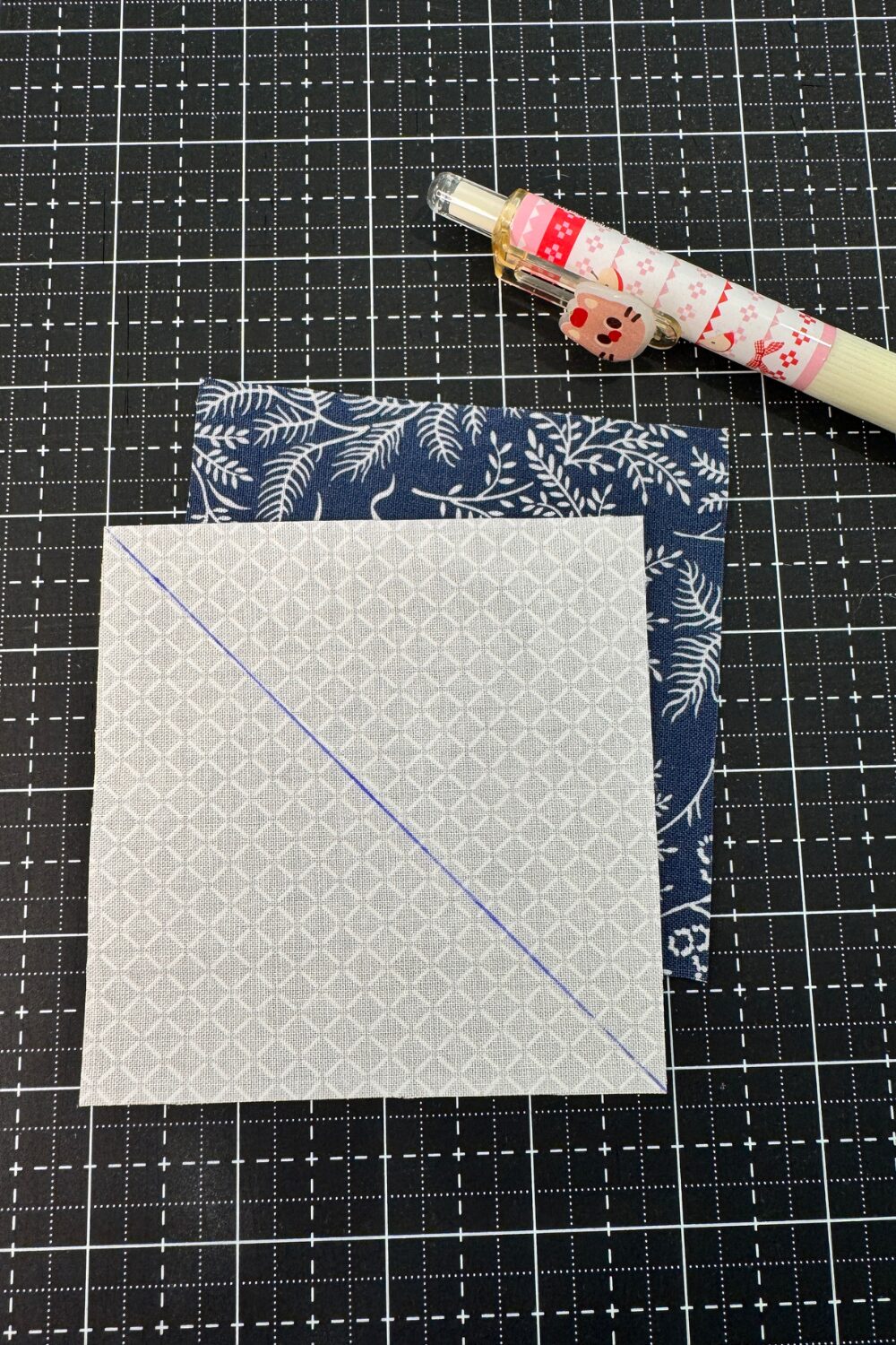 Marking a diagonal line on a square to make half square triangles.  