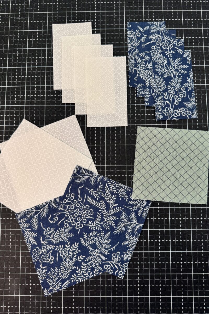 Pieces of fabric needed to make a  churn dash quilt block.  A variety of squares and rectangles.  