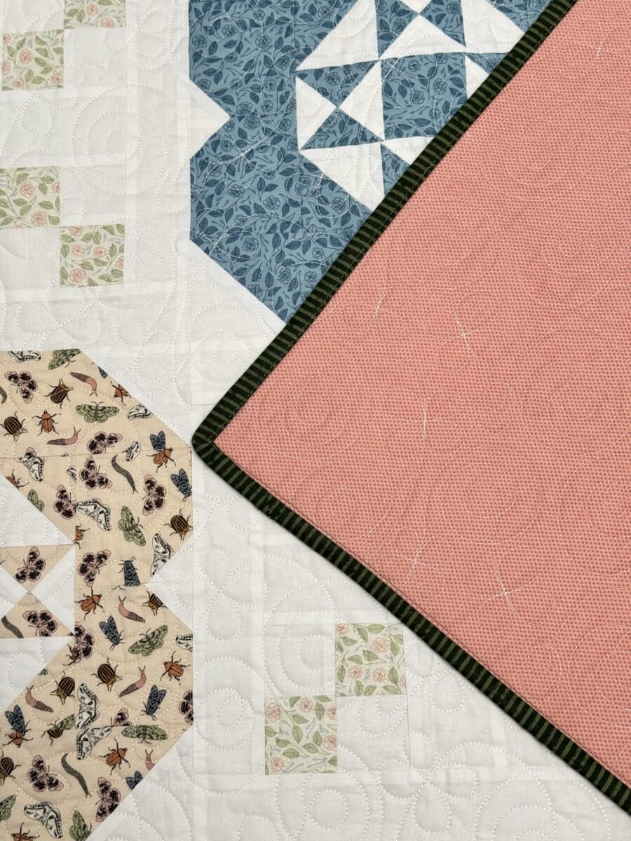 Gardenia quilt with a corner flipped over to show the pink Mellow Rose backing