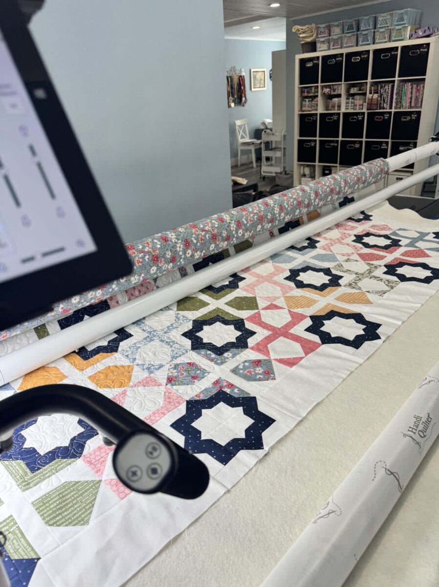 Long arm finishing a quilt on a longarm frame.
