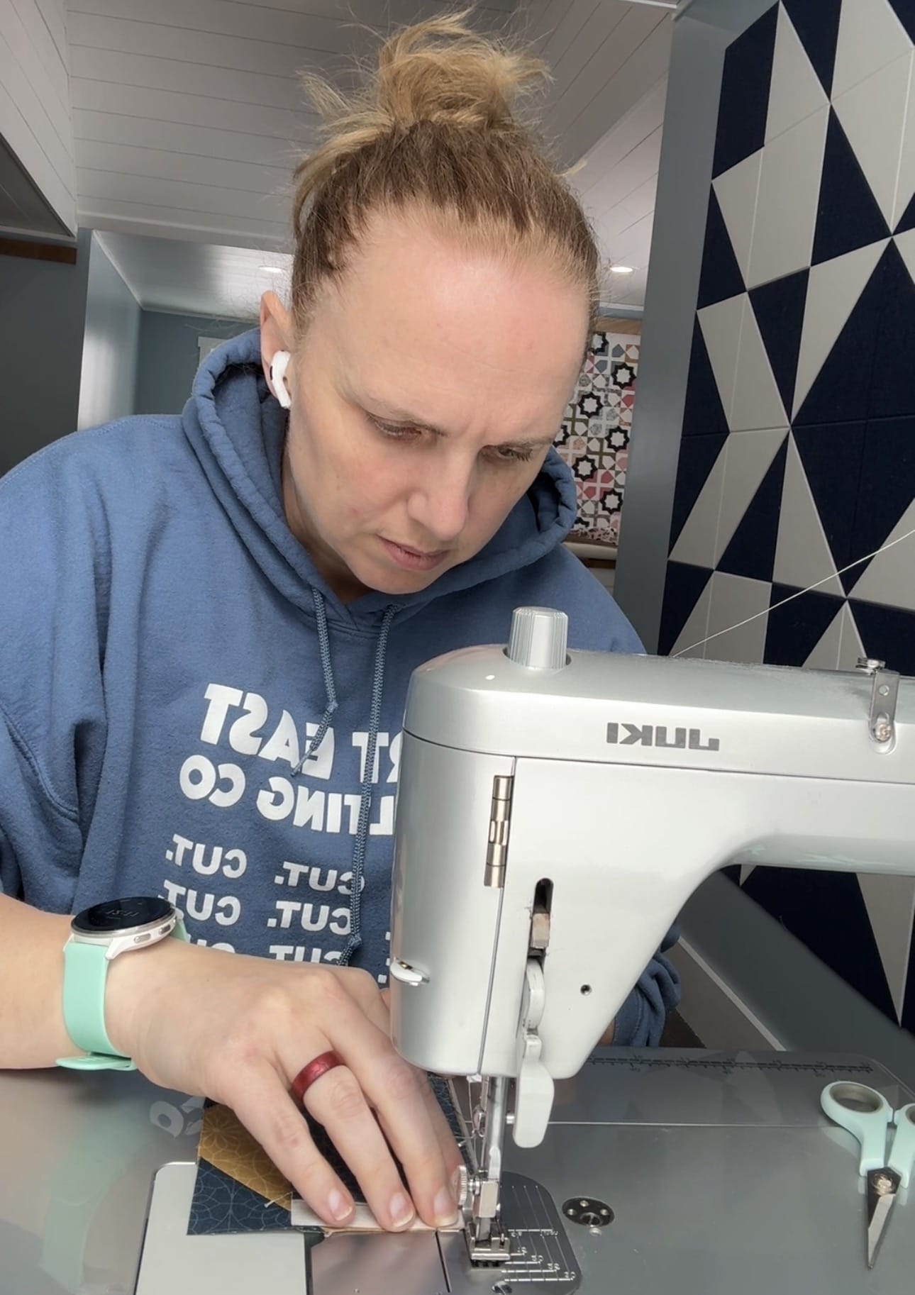 A person sitting at a Juki Sewing Machine